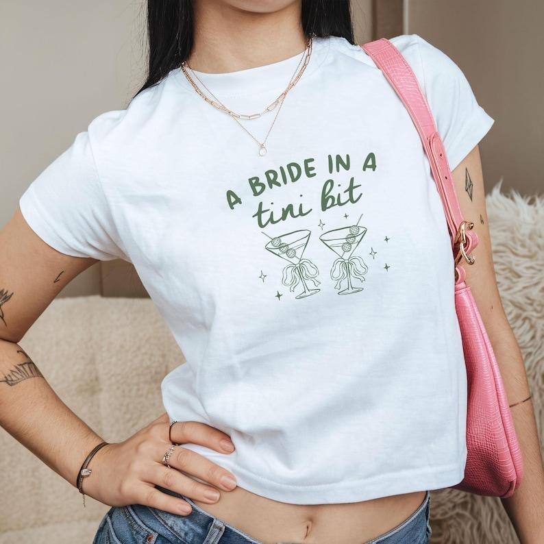 A Bride in A Tini Bit Baby Tee, Bride Shirt Martini Bachelorette Party Croptop, Martini Bride Tee, Gift for Bridesmaid,...