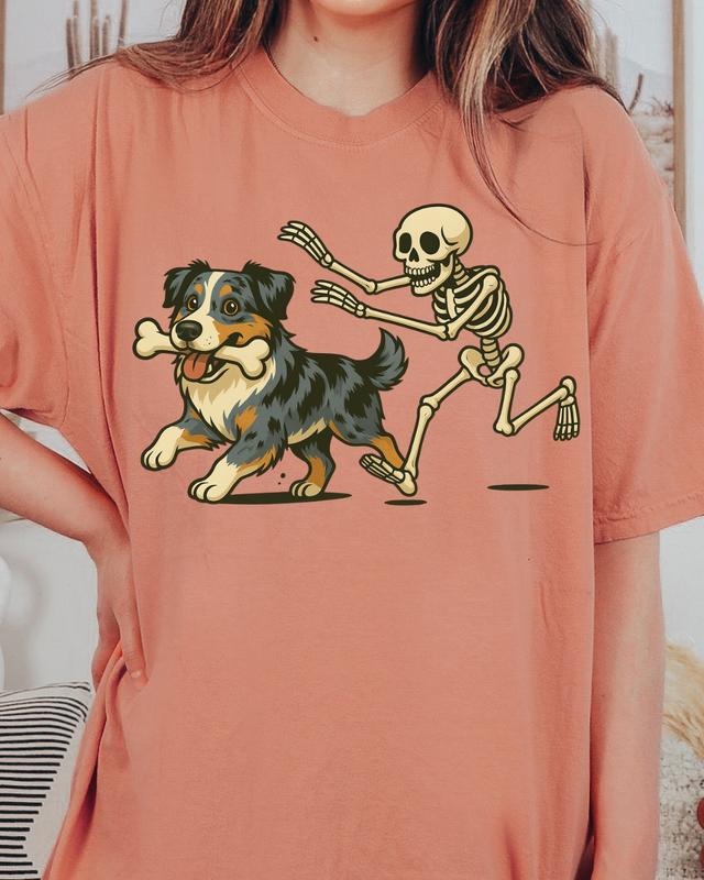 Funny Skeleton Chasing Blue Merle Aussie Dog Halloween T-Shirt | Spooky Graphic Tee Comfort Colors Style Unisex Relaxed...